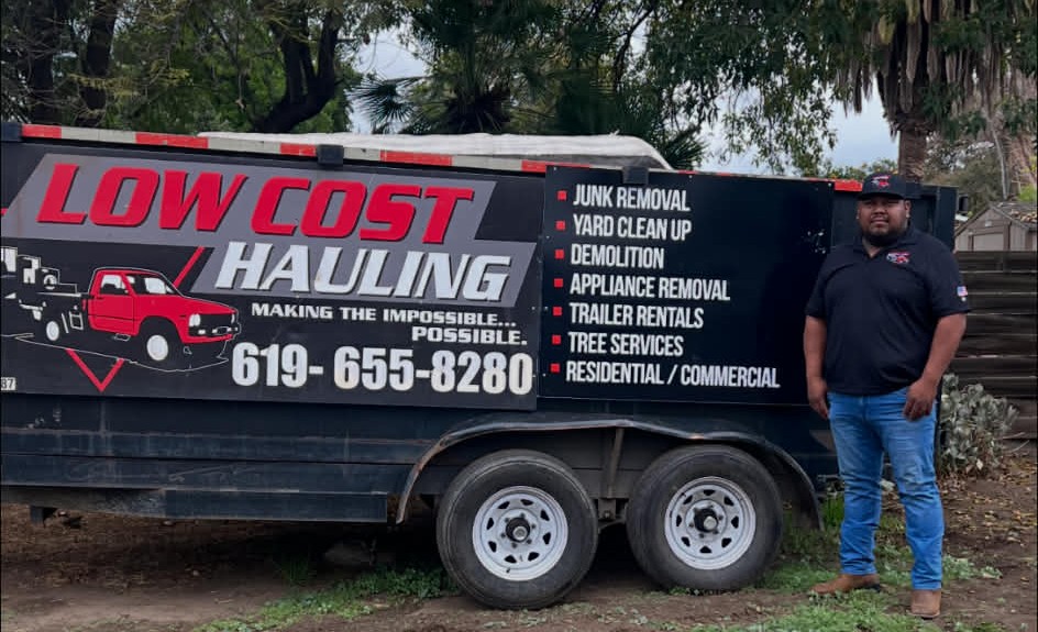 Juan standing next to the Low Cost Hauling branded trailer